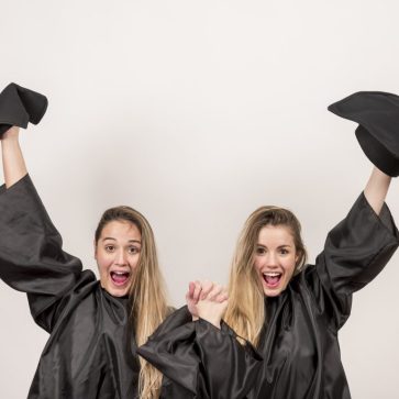 enthusiastic-graduates-holding-up-trenchers