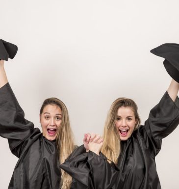 enthusiastic-graduates-holding-up-trenchers